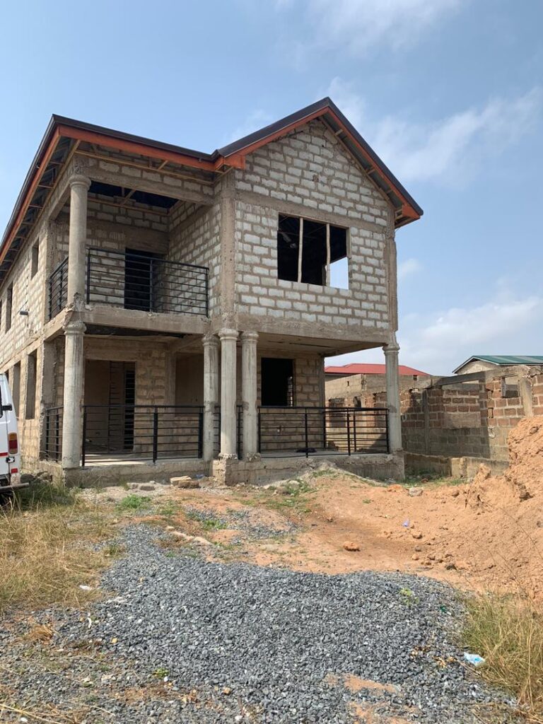 Unfinished two-story house under clear blue sky.