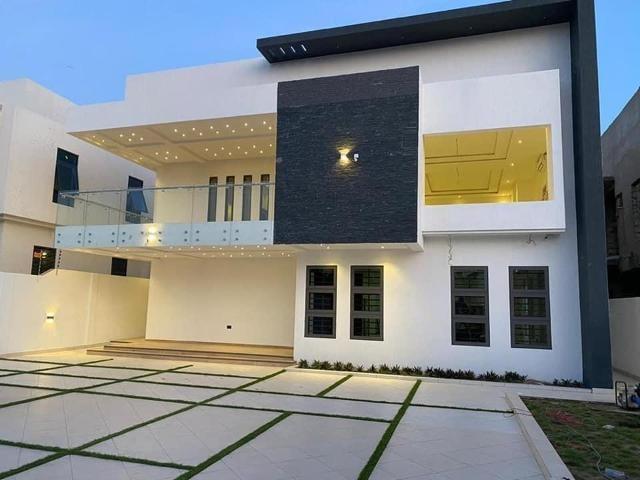 Modern two-story house with white walls and black accent panel.